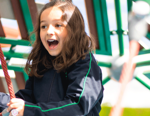 niña feliz jugando en el parque del colegio gimnasio los andes